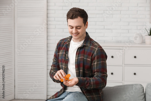 Happy young man taking pill...