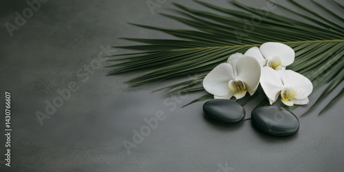 Spa concept background with palm leaf orchids and stones on textured surface