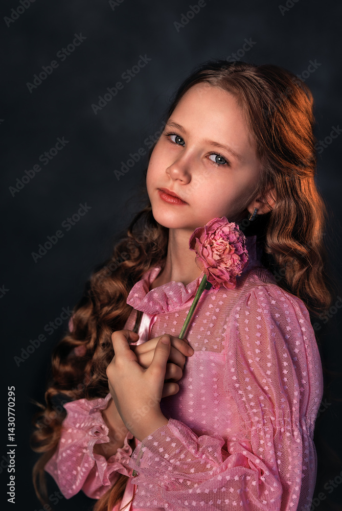 Beautiful girl in a pink dress with a peony flower on a dark background. Romantic, festive image