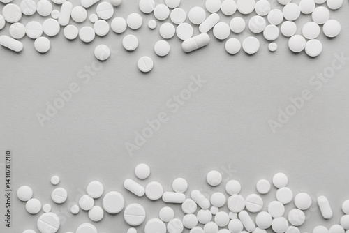 Different white pills on gr...