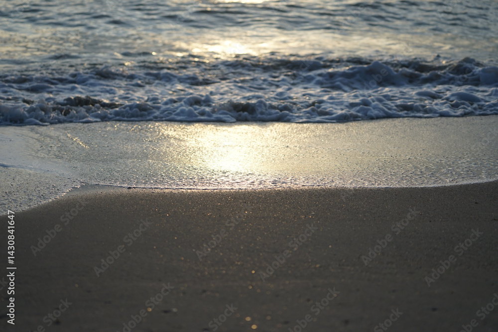 Refletion of the sunlight on the wet beach with wave in background Refletion of the sunlight on the wet beach with wave in background