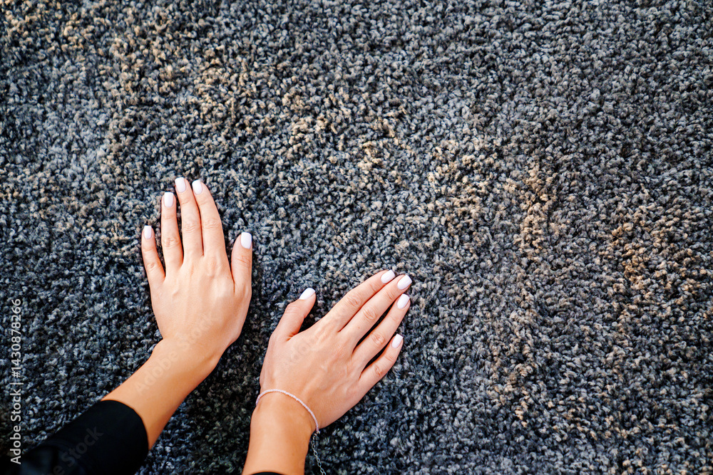 a woman's hand touching the grey Interior pile carpet