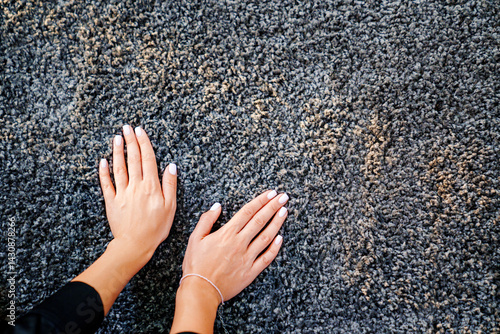 Obraz na płótnie a woman's hand touching the grey Interior pile carpet w salonie