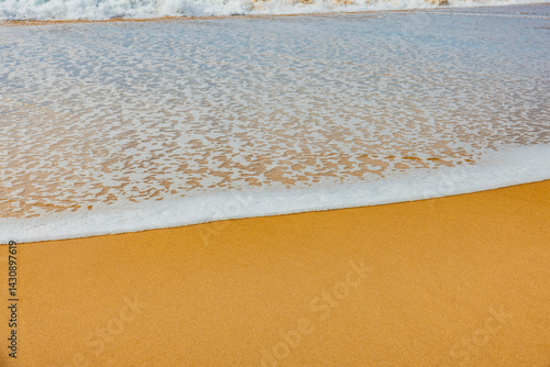 Wasserkaante mit Gischt am sandstrand