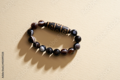 Tibetan  Eyes Dzi beads bracelet on yellow background.