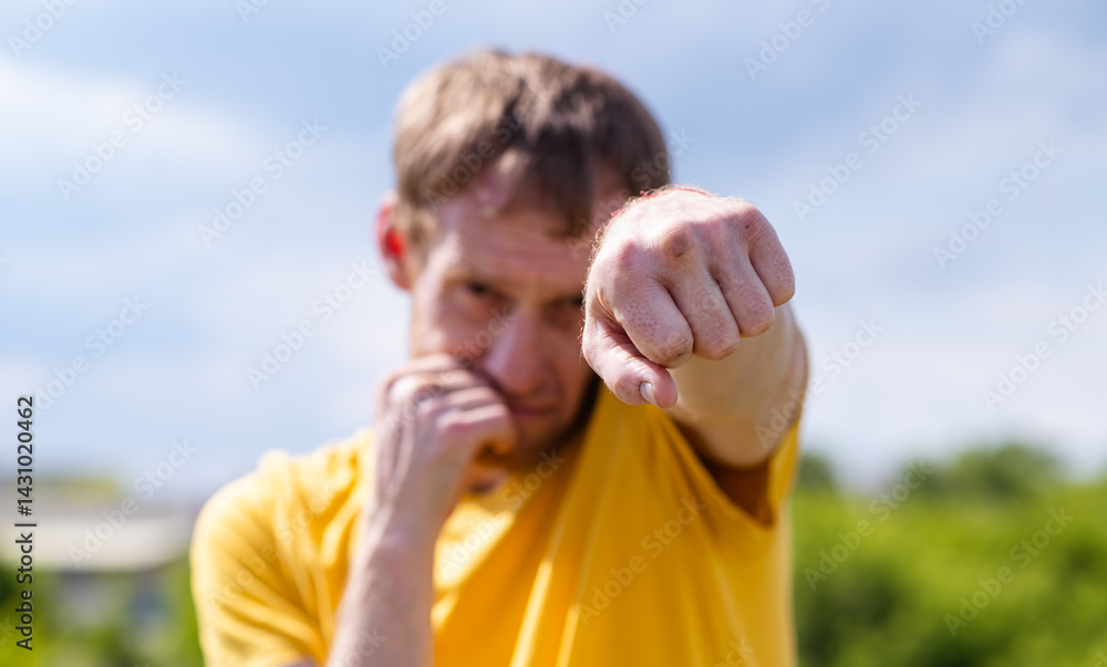 Naklejka premium Man Practicing Boxing Moves in Scenic Park on a Sunny Afternoon