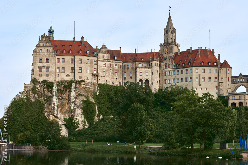 Fototapeta premium Sigmaringen Castle Perched on Rugged Cliff Above Tranquil Danube: Historic Hohenzollern Residence Showcases Medieval Architecture and Royal Collections in Picturesque Baden-Wurttemberg Landscape
