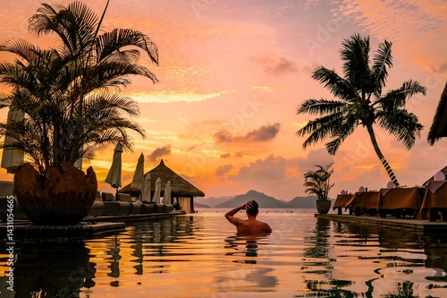 Принти на полотні A young man enjoys a tranquil moment by a luxury swimming pool as the sun sets over the stunning Seychelles islands in La Digue