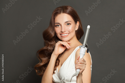 Wallpaper Mural Elegant young model woman with long curly wavy hairstyle showing hot curling tongs iron on white background Torontodigital.ca