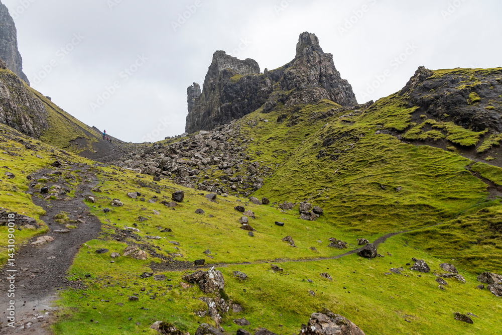 Obraz premium The Quiraing, Isle of Skye lush green landscapes, pure air, dramatic cliffs. A surreal trail through wild nature, perfect for trekking, silence, breathing untouched beauty, mystical rock formations.
