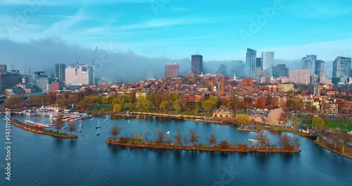 Approaching bright urban landscape with old-style buildings. Thick fog covers the high-rise buildings at backdrop. Boston, Massachusetts, USA.
