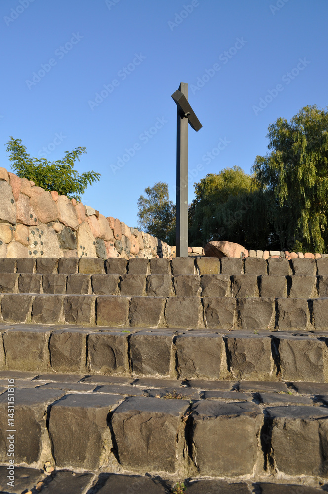 Christian cross high monument in the cemetery stairs