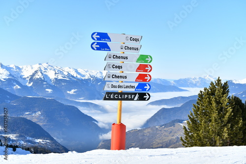 Direction signs on the slopes of Courchevel ski resort showing Chênus and Coqs slopes