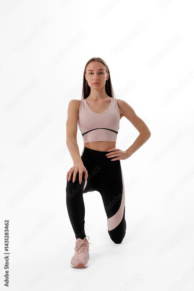 Fitness model posing in athletic wear during a workout session in a minimalist studio environment Fitness model posing in athletic wear during a workout session in a minimalist studio environment
