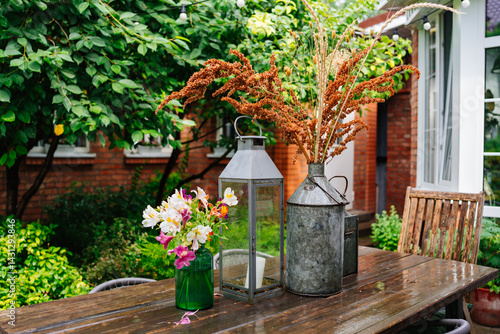 Obraz na płótnie wooden table with lanterns and dried flowers. The yard in the house. w salonie