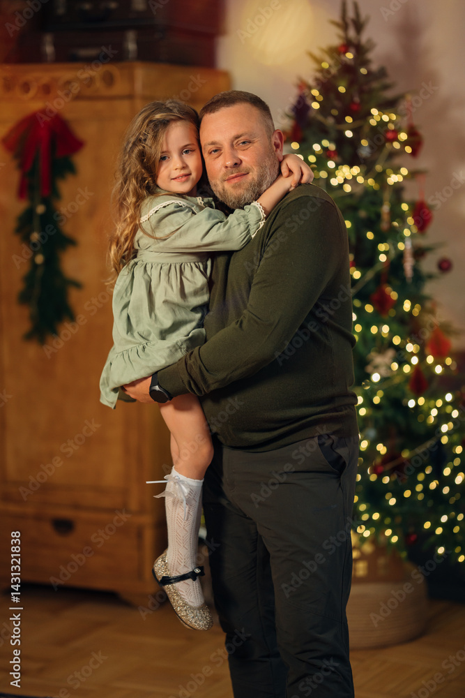dad and little daughter at the Christmas tree.