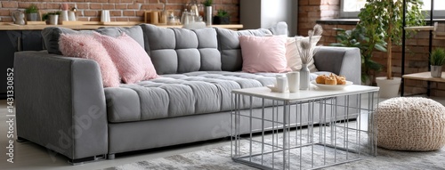 Obraz na płótnie Close-up of a comfortable gray sofa with decorative pillow and rustic coffee table in a warmly decorated living room w salonie
