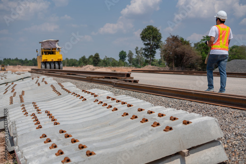 Obraz na płótnie Railway construction: A focused construction worker oversees a railway's construction, with an emphasis on precision and infrastructure development. w salonie