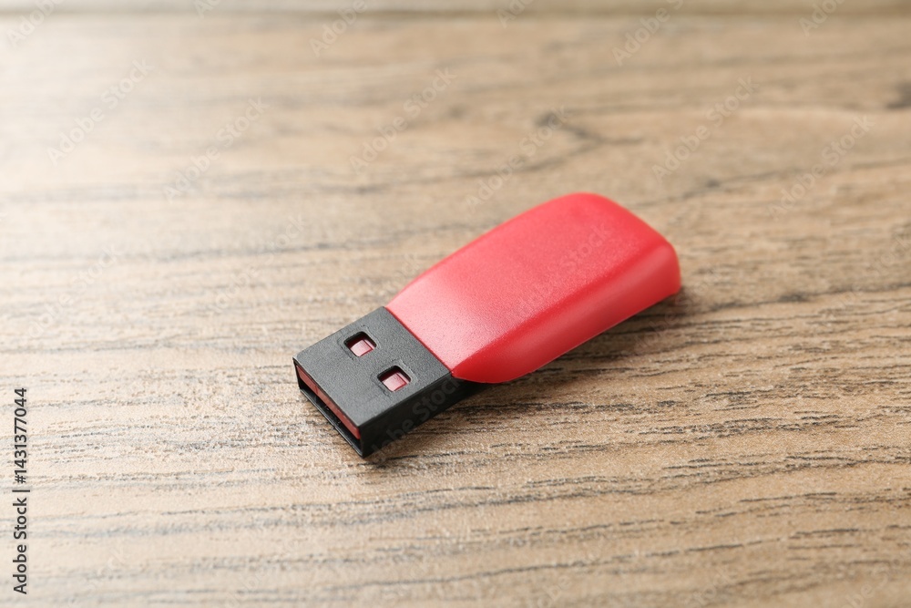 One flash drive on wooden background, closeup One flash drive on wooden background, closeup