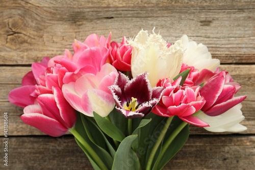 Beautiful tulips on wooden background, top view