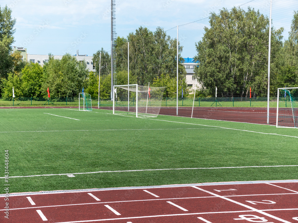 Fototapeta premium Red treadmill at the stadium with white lines