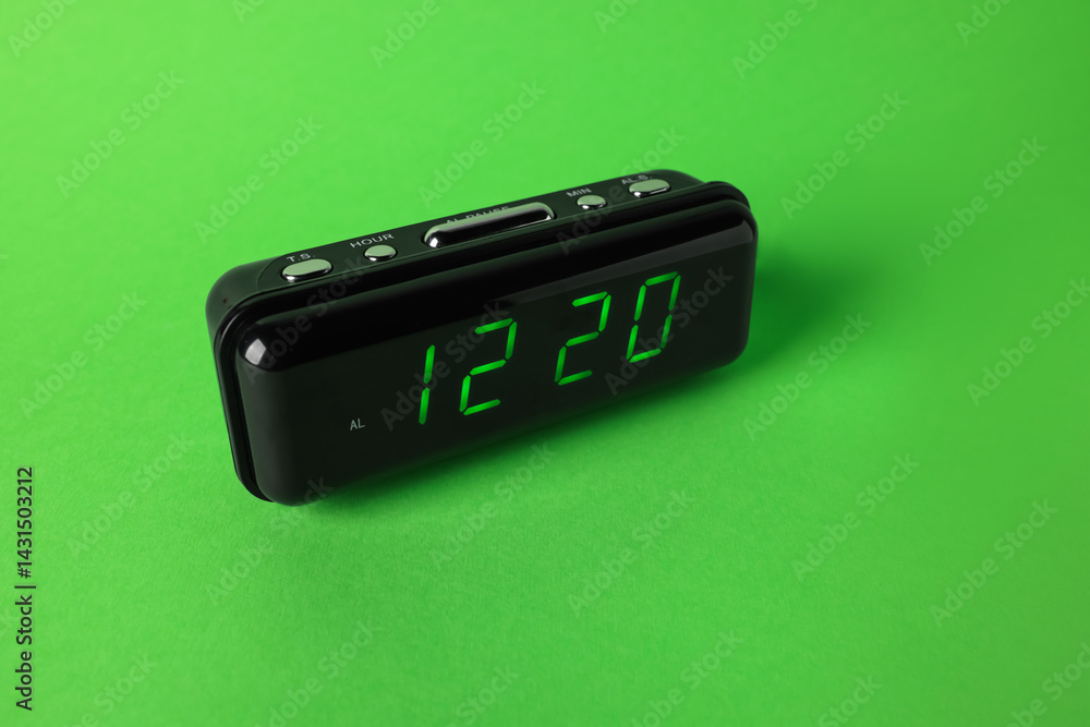 Digital alarm clock showing 12:20 o'clock on green background Digital alarm clock showing 12:20 o'clock on green background