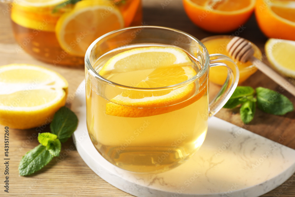 Aromatic fruit tea in glass cup, orange, lemon, honey and mint on wooden table, closeup Aromatic fruit tea in glass cup, orange, lemon, honey and mint on wooden table, closeup