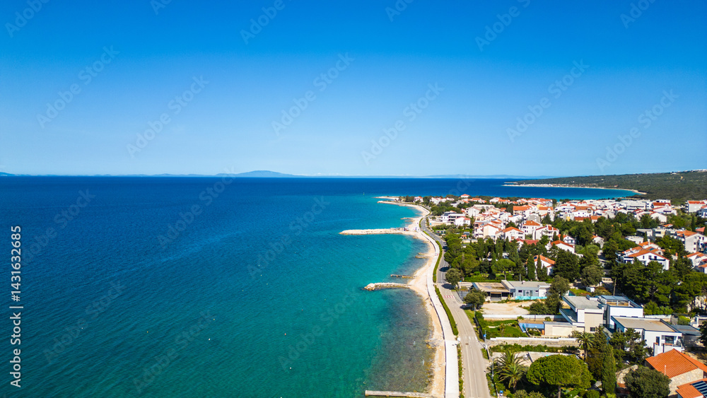 Fototapeta premium Aerial view of Novalja on Pag Island, Croatia. Famous for its beaches, vibrant summer atmosphere, and scenic Adriatic coastline. Captured by drone for a stunning panoramic perspective