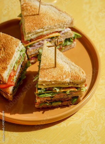 club sandwich served on a wooden cutting board. The sandwich is layered with crispy toasted bread, fresh lettuce, ripe tomatoes, slices of ham, and cheese