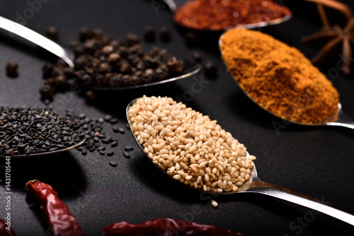 Horizontal soft focus group of spices, sesame, pepper, turmeric, cayenne peper