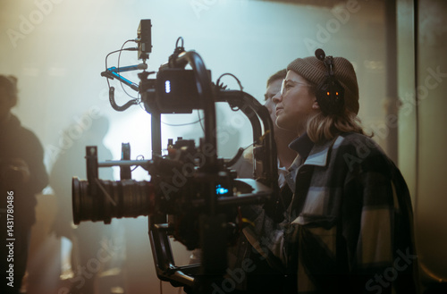 A female director at work on the set. The director works with a band or with a speaker during the filming of a movie, commercial, or television series. The crew, equipment, and crew. 