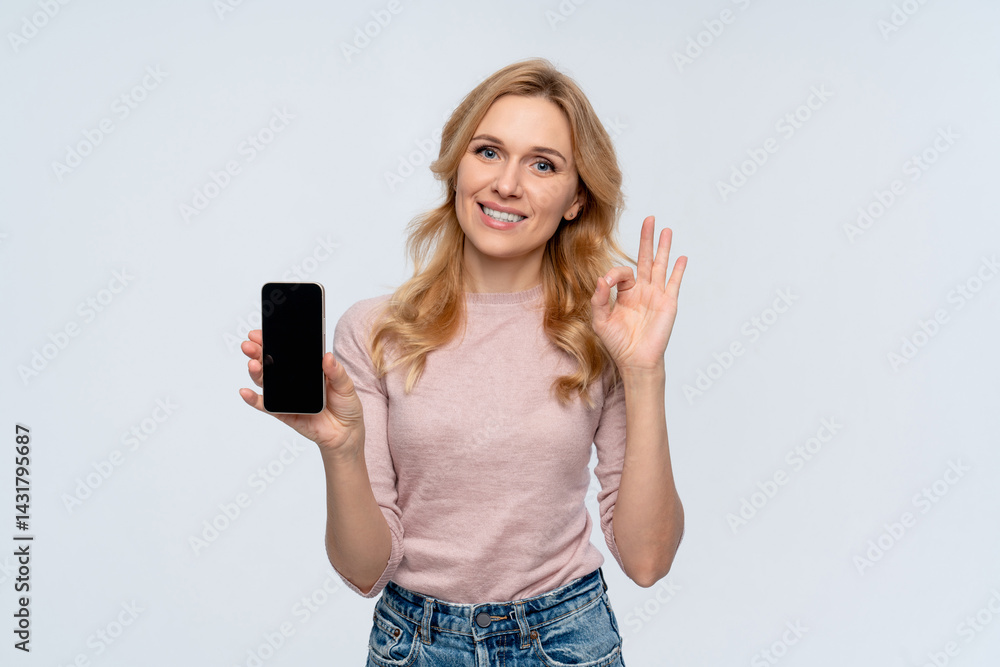 Charming young woman female manager holding using smart cell mobile phone demonstrate mock up blank screen showing ok okay sign gesture isolated on white background copy space. Technology concept Charming young woman female manager holding using smart cell mobile phone demonstrate mock up blank screen showing ok okay sign gesture isolated on white background copy space. Technology concept