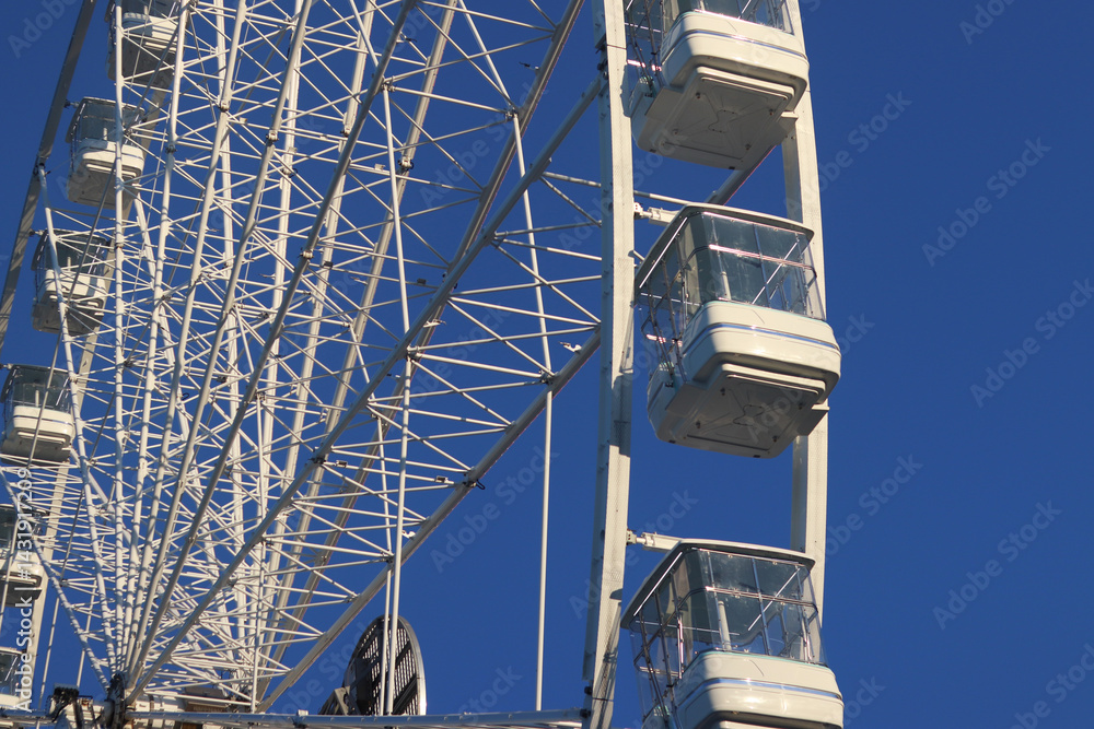 Ferris wheel against blue sky. Amusement park. Close-up of Ferris wheel cabins
