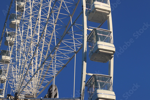 Obraz na płótnie Ferris wheel against blue sky. Amusement park. Close-up of Ferris wheel cabins w salonie