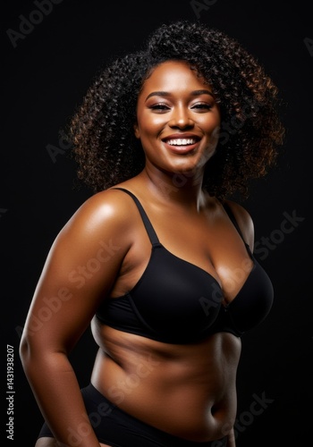 Confident woman smiling in black lingerie against dark background
