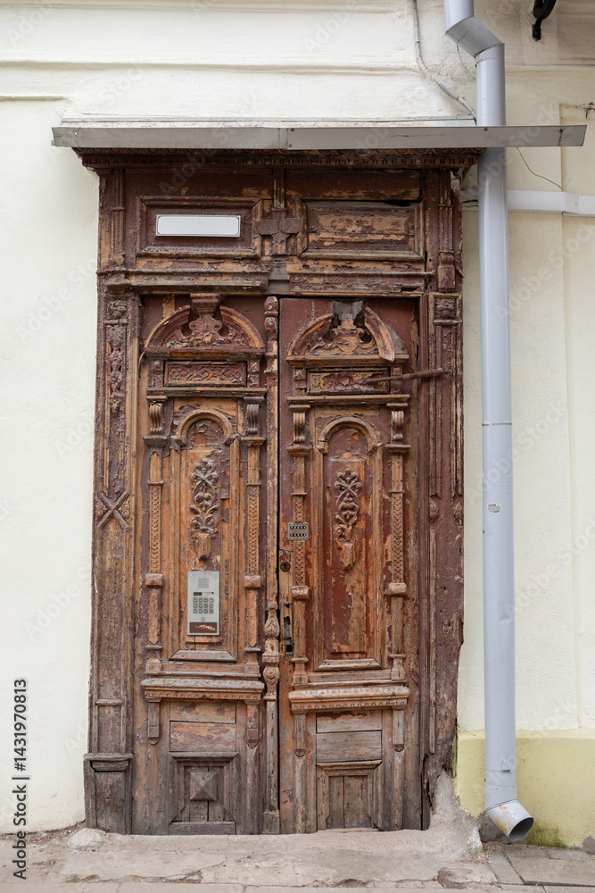 Weathered Historic Wooden Door with Carved Details in Old Town Vilnius, Lithuania Weathered Historic Wooden Door with Carved Details in Old Town Vilnius, Lithuania