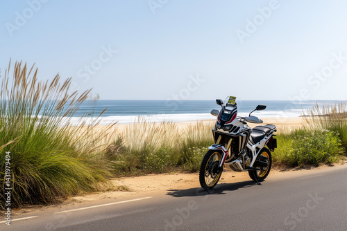 Motorcycle parked on a scenic beach road under a clear sky  