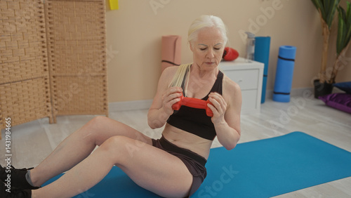 Obraz na płótnie Woman exercising with dumbbells in a gym surrounded by fitness equipment highlighting active lifestyle and strength training indoors. w salonie