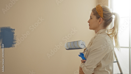 Obraz na płótnie Woman painting wall in bright apartment holding roller with calm focus showcasing home improvement skills and style in bright sunlit interior space w salonie