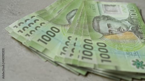 Obraz na płótnie Chilean banknotes of 1000 pesos stacked on a concrete surface highlighting the currency intricacies. w salonie