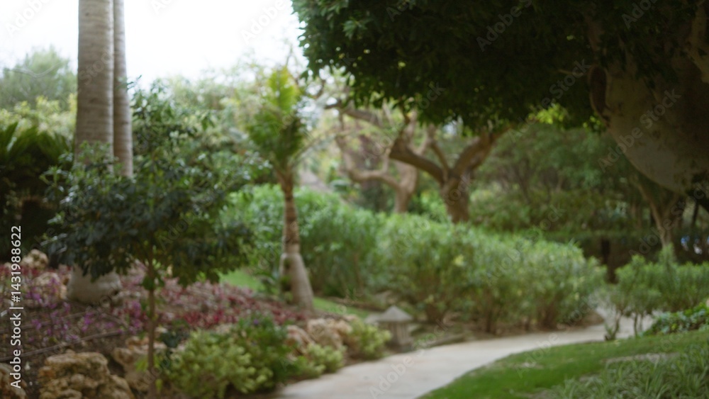 Lush tropical garden with defocused greenery and pathway in luxury resort featuring serene ambiance and vibrant plant life, perfect for relaxation and wanderlust. Lush tropical garden with defocused greenery and pathway in luxury resort featuring serene ambiance and vibrant plant life, perfect for relaxation and wanderlust.