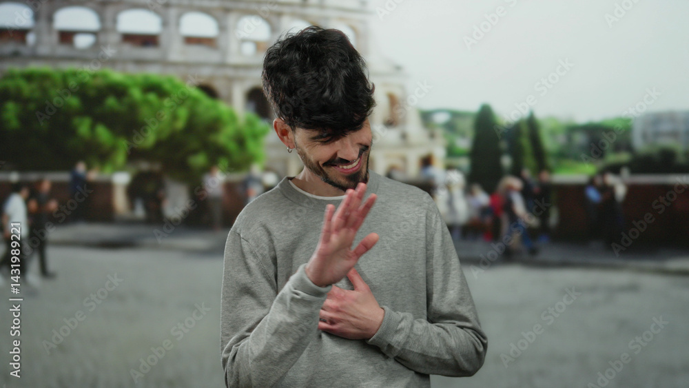 Young man smiling in front of the iconic roman coliseum, capturing a casual outdoor moment in an urban city setting with a vibrant street atmosphere.