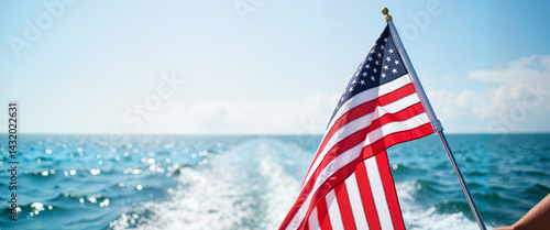 American flag waving on a boat in calm ocean waters, symbolizing freedom and patriotism. July 4,  Independence Day concept