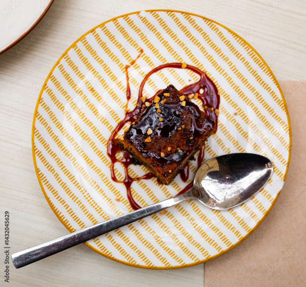 Fototapeta premium Slice of fresh carrot cake served on plate. Confectionery served on table in restaurant.