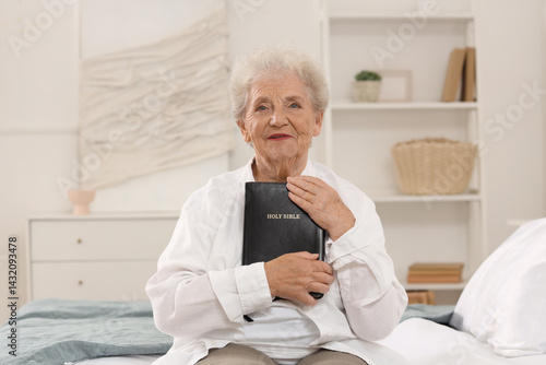 Senior woman with Bible sit...