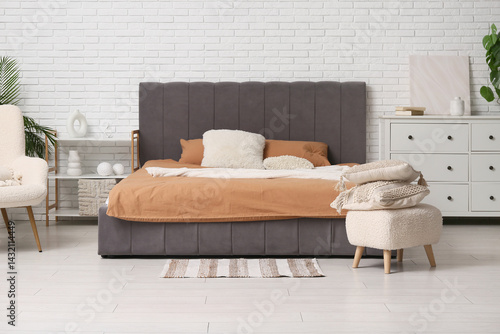 Wallpaper Mural Soft comfortable bed with pillows, shelving unit, chest of drawers and pouf with cushions in interior of bedroom Torontodigital.ca