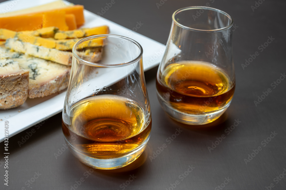 Whiskey and cheese pairing, tasting speyside whisky glasses and plate with sliced cheddar, blue stilton and blue shropshire cheeses, Great Britain food and drink Whiskey and cheese pairing, tasting speyside whisky glasses and plate with sliced cheddar, blue stilton and blue shropshire cheeses, Great Britain food and drink
