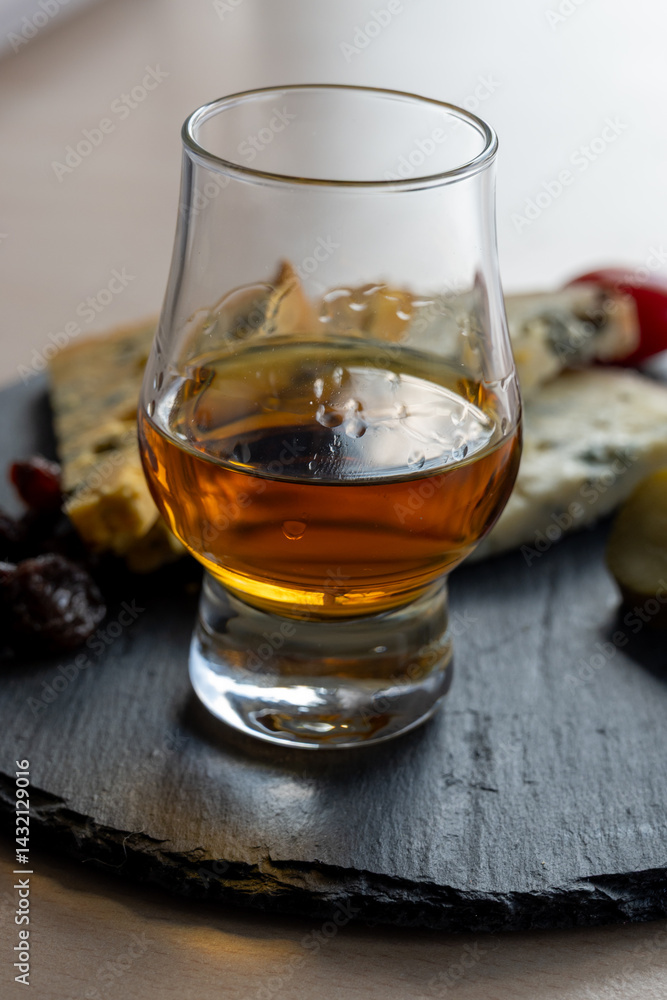 Whiskey and cheese pairing, tasting whisky glass and plate with sliced blue stilton and blue shropshire cheeses, Great Britain food and drink Whiskey and cheese pairing, tasting whisky glass and plate with sliced blue stilton and blue shropshire cheeses, Great Britain food and drink
