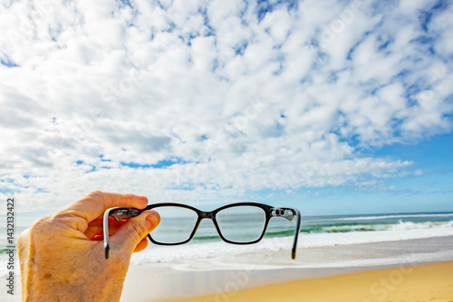Lesebrille vor einem Horizont über Wasser