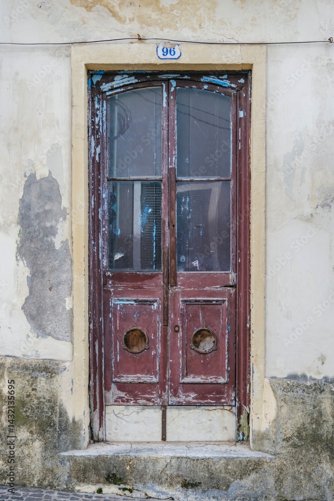 Rustic Charm of a Weathered Doorway: Vintage Architectural Detail in Azores Islands. Old wooden door, distressed paint, weathered texture. Vintage architectural detail showcases a timeworn entrance